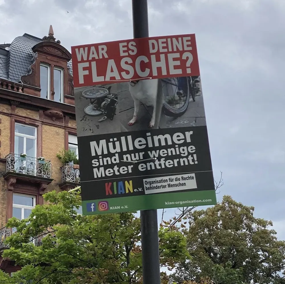 Ein Plakat an einem Laternenmast mit der Aufschrift „War es deine Flasche?“ und „Mülleimer sind nur wenige Meter entfernt!“, darunter ein Foto von Scherben auf dem Gehweg.